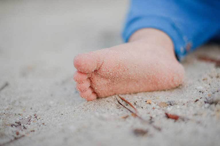 Warzen an Kinderfüßen: Kinderfuss im Sand